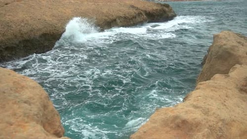 The Waves Beat Against the Rocks. Storm on the Mediterranean Sea. The Sea Is Turquoise. Slow Motion.
