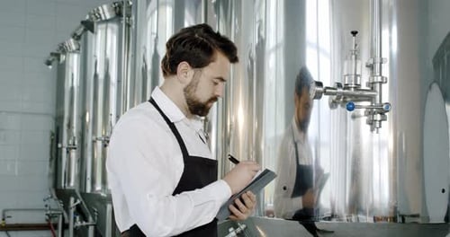 Brauereiarbeiter überprüft Getränkeausrüstung in einer Brauerei oder Bierfabrik. Bierherstellung.