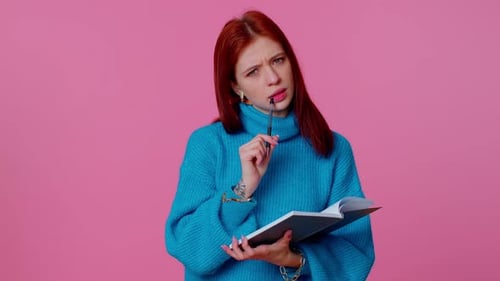 Woman Writes in Notebook on Pink Background