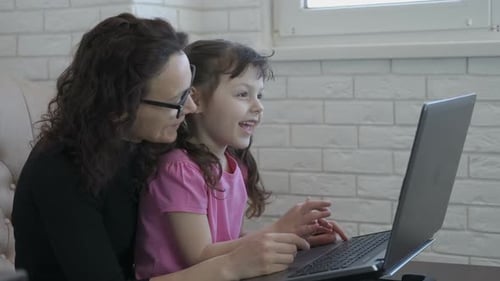 Woman and Child Use Laptop Computer Together