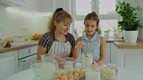 Woman and Child Baking Together in Bright Kitchen