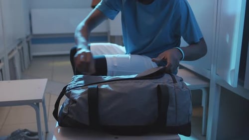 Young Adult Retrieves Gear in Locker Room