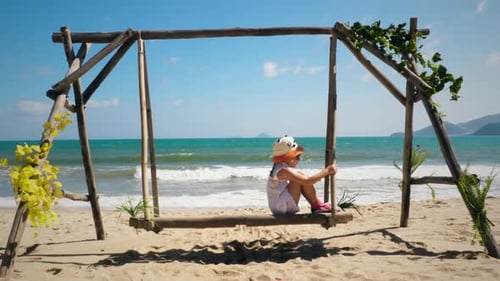 Girl on a swing by the ocean