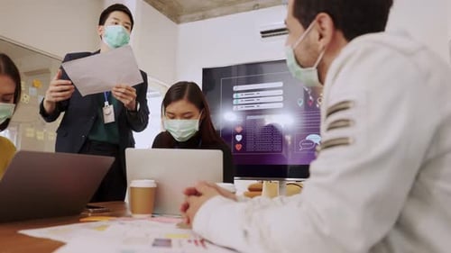 Team Working Together in an Office With Face Masks