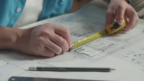 Close Up Of Hand's Man Engineer Measuring Blueprint At The Office