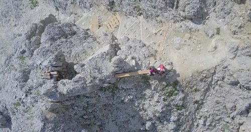 Aerial drone view of a man and woman couple hiking in the mountains