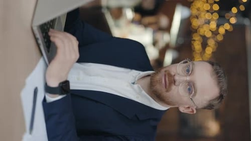Man Working on Laptop in Cafe Setting