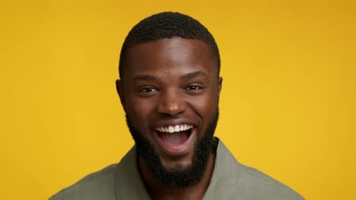 Man Smiling with Open Mouth on Yellow Background