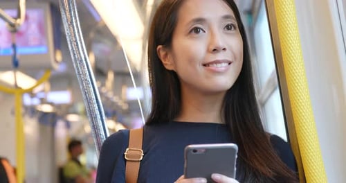 Young Woman Using Smartphone on Commuter Train