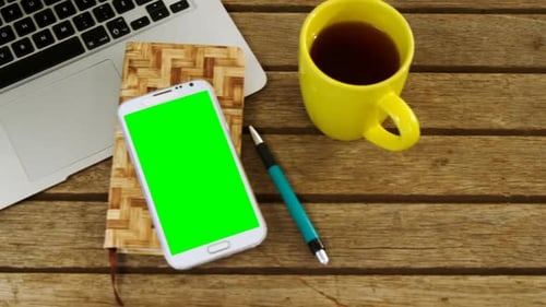 Tech on Wooden Desk with Green Screen Phone