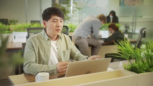 Young Adult Taking Off Mask in Modern Office