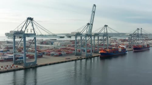 Unbeschäftigte Containerwerft mit immenser Aussicht auf das Meerwasser und den hellblauen Himmel