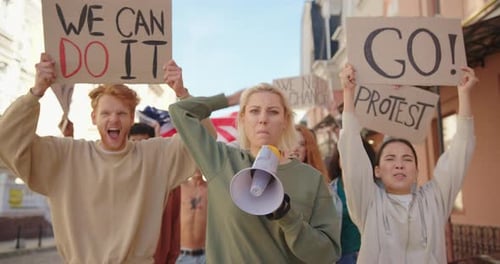 People Marching and Protesting Down City Street