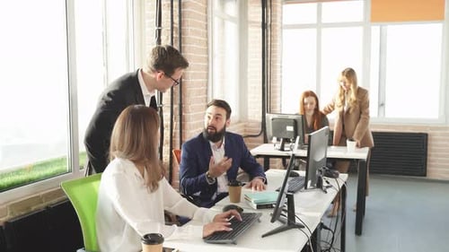 Young Businesss Ladies Sitting in Modern Office and Using Computer Discussing