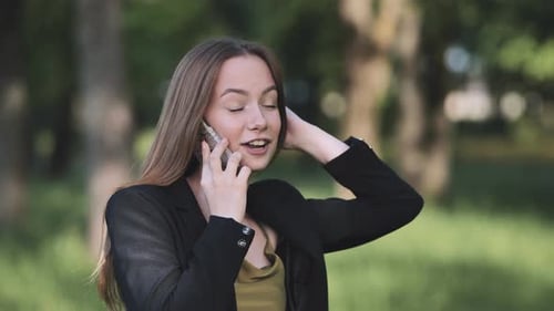 A Young Student Talking on the Phone in the Park