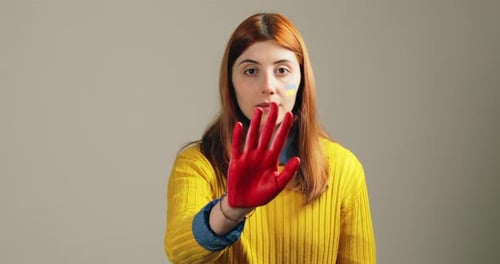 Niña con la mano roja en la mano para detener la violencia