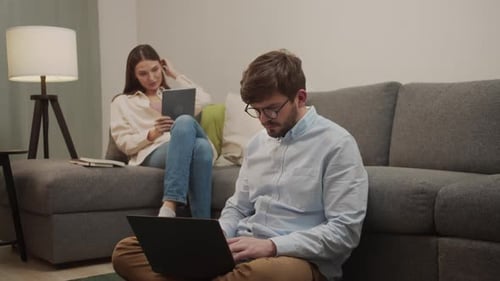 Man and Woman Using Technology at Home