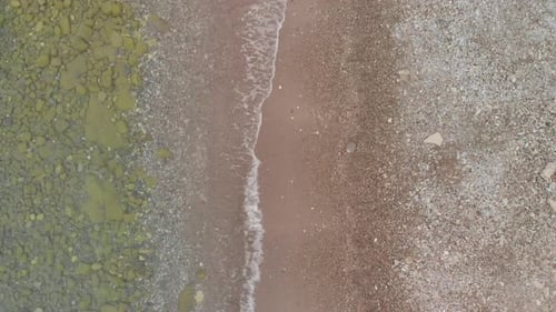 Imágenes aéreas de Zumbido en cámara lenta de olas que golpean la playa en el mar adriático.
