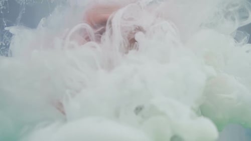 In
Flüssigkeit gefallene Acrylfarben. Abstrakter Schneesturm im Glas, Trockeneis-Wissenschaftskonzept