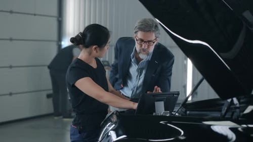 Female Mechanic Consulting a Client
