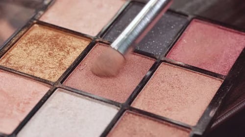 Close Up of Make Up Brush and Eyeshadows Palette on Vanity Table