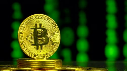 Schuss von Bitcoin mit Binärcode-Blockchain-Hintergrund hautnah