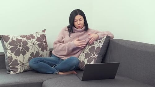Woman Talking in Front of Laptop on Couch