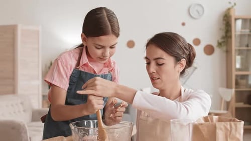 Child Helping Woman Stir Dessert Mixture