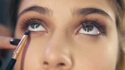 Closeup View of Professional Makeup Artist Hands Using Makeup Brush to Apply Eye Shadows