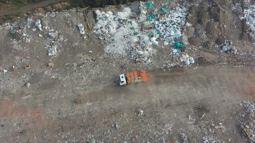 Aerial Shot of Big Rubbish Pile Lying Among Field in Countryside. Flying Over Garbage