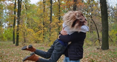 Happy Young Couple in the Autumn Forest Show Their Feelings Fool Around Hug