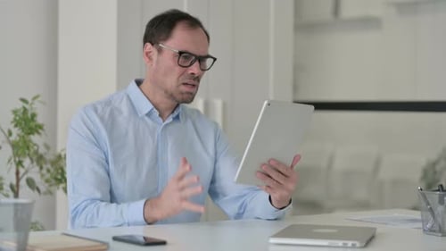 Middle Aged Man Having Loss on Tablet in Office