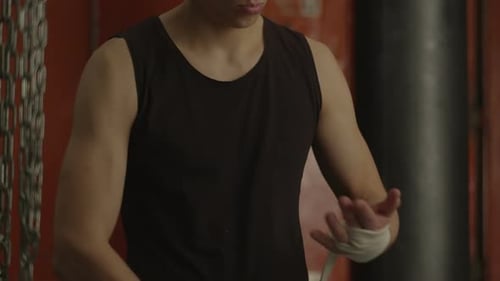 Man Wrapping Hands in Boxing Gym Preparation