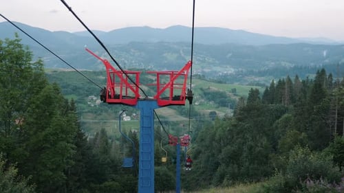Chairlift mechanism. Steel rope tow in green forest