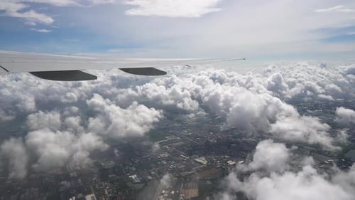 Vista desde el avión volando a través de las nubes sobre la ciudad