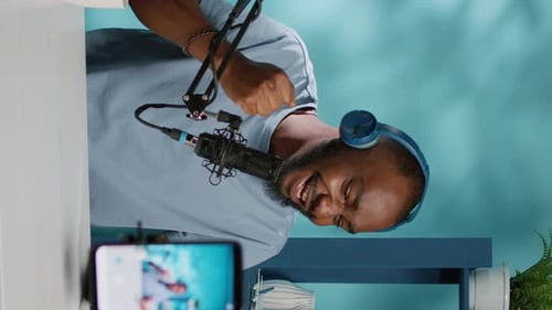 Vertical Video Black Vlogger Filming Podcast on Smartphone in Studio
