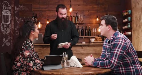 Couple Ordering Food from Waiter in Restaurant