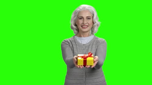 Senior Woman Holding Gift Box on Green Screen
