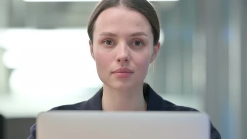 Smiling Woman At Computer In Office Setting