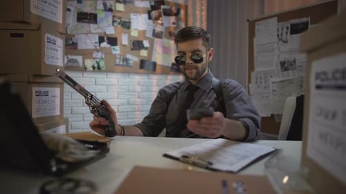 Young Adult Talks on Phone While Holding Gun