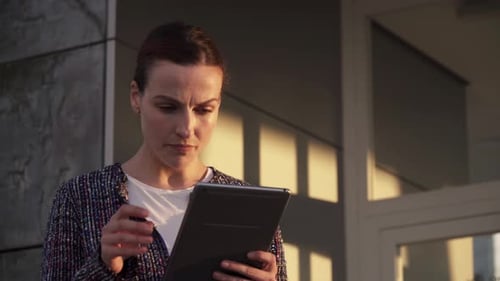 Confident entrepreneur with tablet on city street