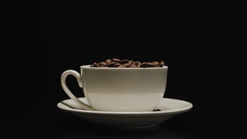 Coffee Beans Falling into Cup Close Up