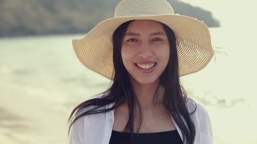Smiling of portrait Asian woman standing on the beach feeling happy holiday travel beautiful sunset.