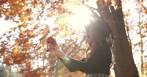Attractive Woman in a Special Dress and Hat Looks Like a Witch in the Autumn Forest