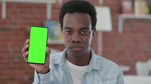 Young Adult Holding Smartphone with Green Screen