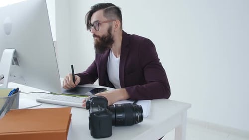 Bearded Man Designs on Computer with Graphics Tablet