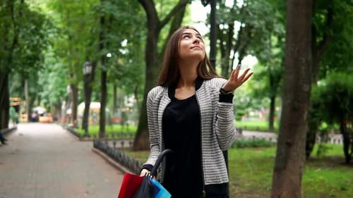 Woman Opens Colorful Umbrella in Green Urban Park