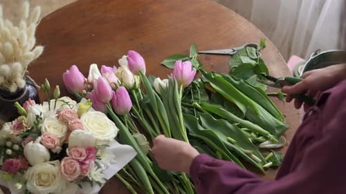 Woman Arranging Flowers on a Table