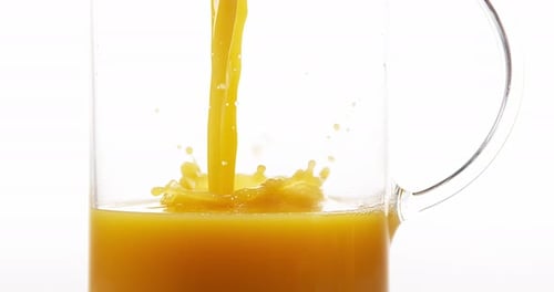 Pouring yellow liquid into a glass pitcher
