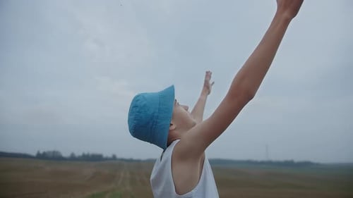 Child with Arms Raised in Peaceful Rural Field